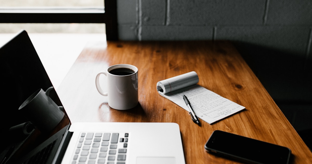 A clean desk setup with a laptop and coffee showing productivity